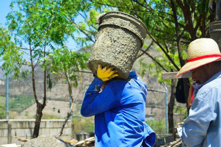 Fortes chaleurs au travail : ouvrier exposé au soleil sur un chantier