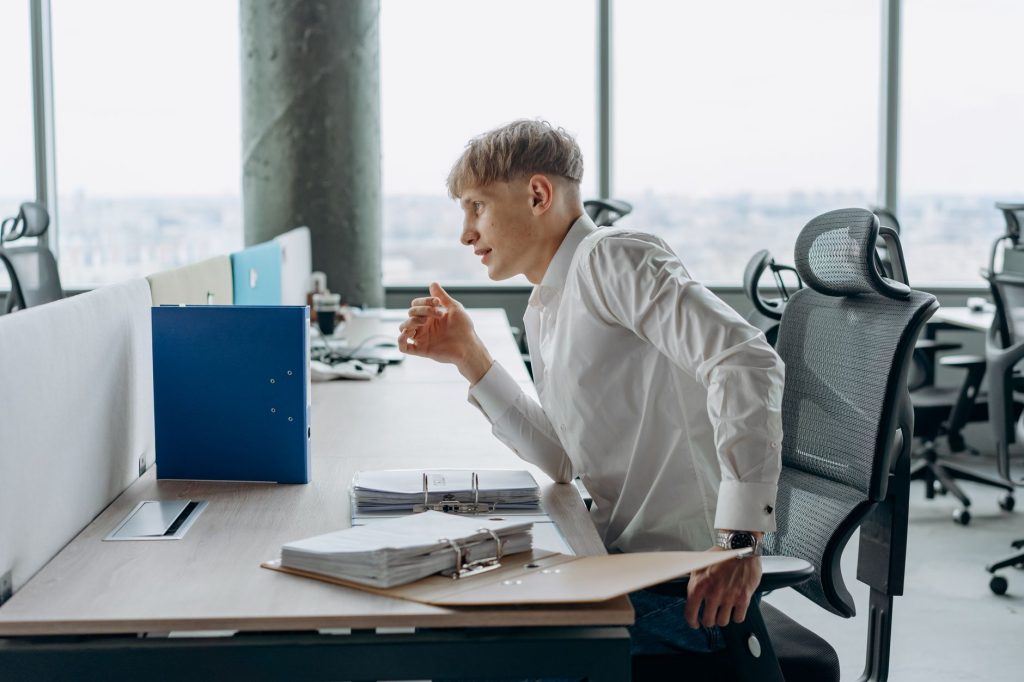 Ergonomie au poste de travail : salarié ajustant la hauteur de son écran