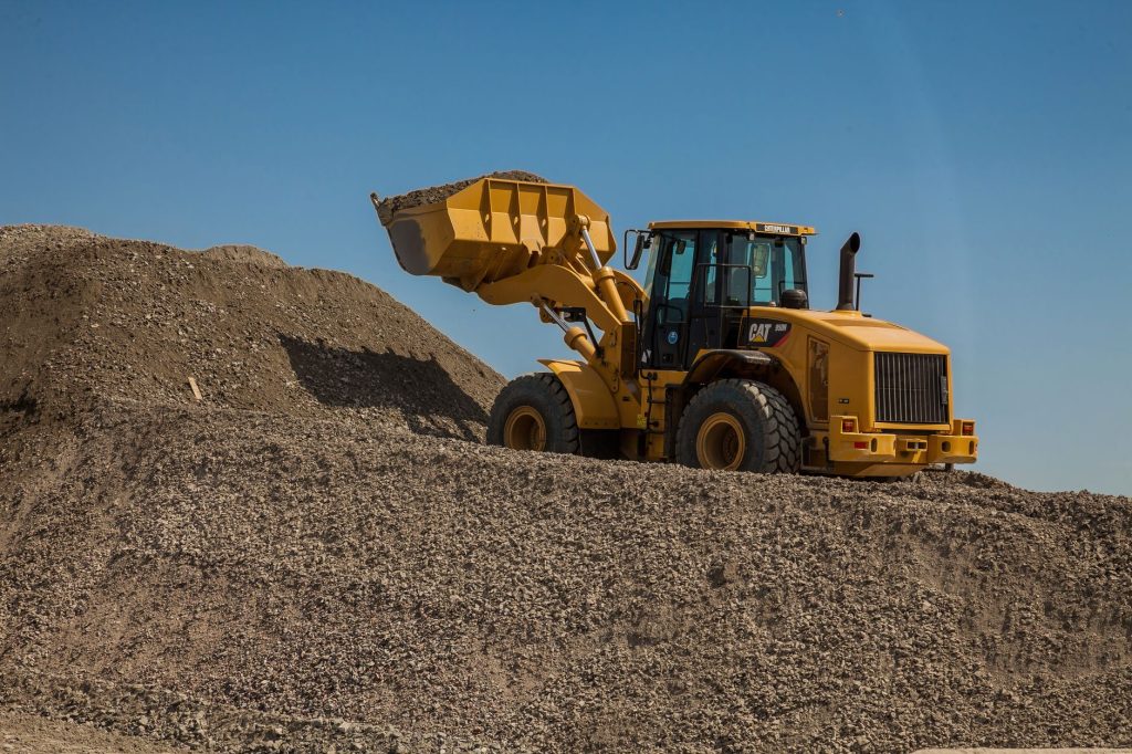 CACES R482 catégorie C1 : une chargeuse sur pneus, godet chargé, sur un tas de granulats