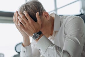 Harcèlement moral au travail : un salarié seul à son poste, la tête dans les mains