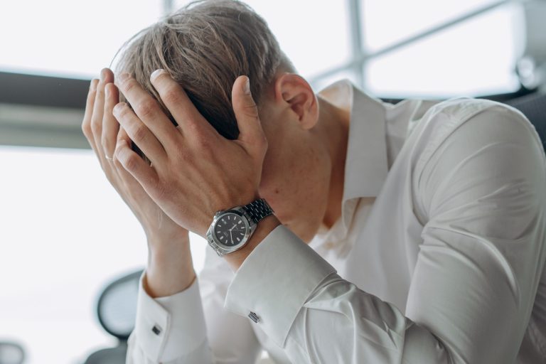 Harcèlement moral au travail : un salarié seul à son poste, la tête dans les mains