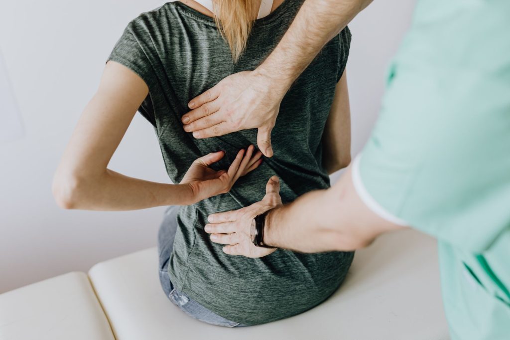 Ostéopathie en entreprise : praticien examinant le dos d'un patient