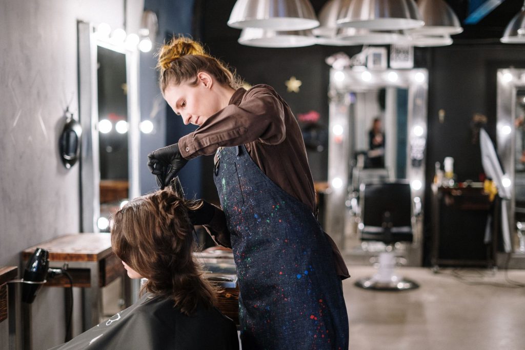 DUERP coiffure : coiffeuse au travail avec une cliente en salon